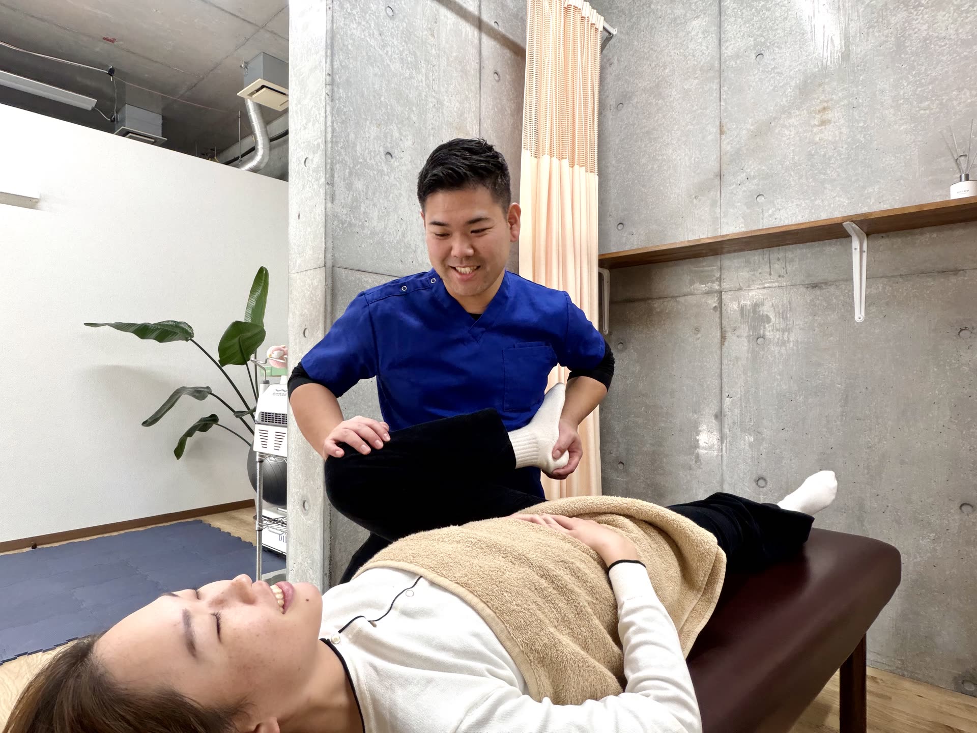脚を支えながら身体の動きを確認する様子